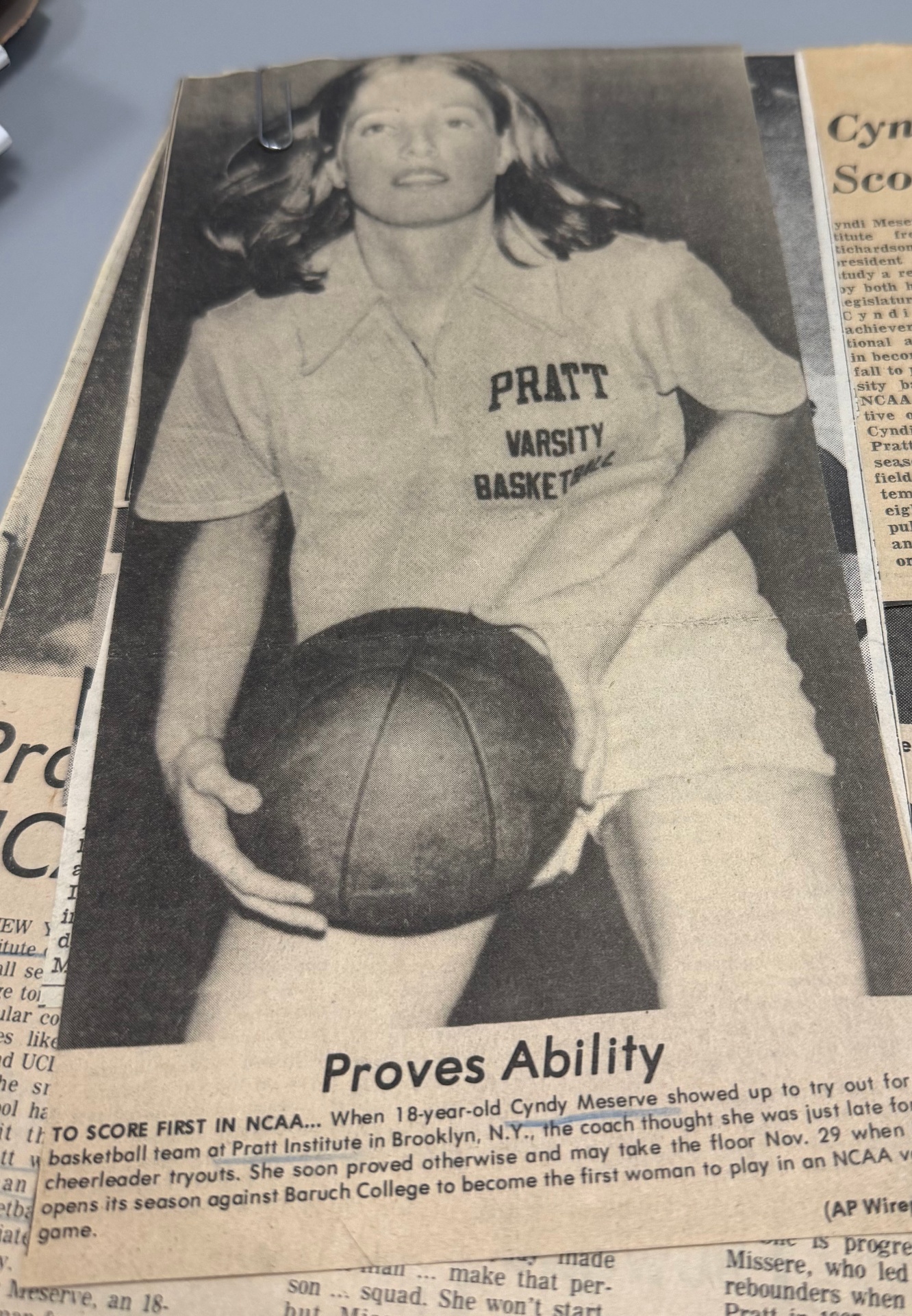 Newspaper photograph of Cyndy Meserve in her Pratt Varsity Basketball uniform, holding a basketball, under the headline 'Proves Ability.'